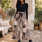 Pantalon large femme imprimé géométrique dans les tons taupe et beige, porté sur mannequin avec un top noir, ceinturé à la taille, dans un décor extérieur bohème chic et naturel.
